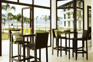 mesa de comedor y sillas con vistas al océano en Kamana Sanctuary Resort & Spa, en Olóngapo