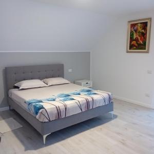1 cama en un dormitorio con una pared blanca en Casa Mont Blanc apartament 1, en Cavnic