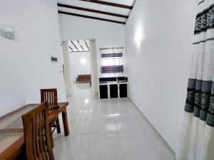 a living room with a table and chairs and a white floor at Comfortable Stay in Colombo in Rajagiriya