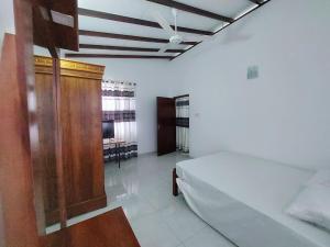 a bedroom with a bed and a wooden cabinet at Comfortable Stay in Colombo in Rajagiriya
