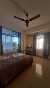 a bedroom with a bed and a ceiling fan at m&b homestay in Itānagar