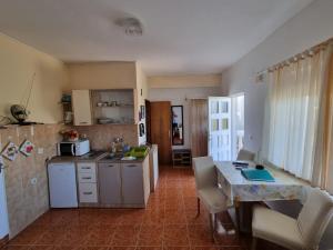 a kitchen with a counter and a table with chairs at Apartment Tino in Sukošan
