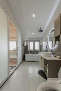 a white bathroom with a tub and a sink at Jodi Dalat Hotel in Da Lat