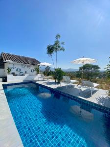 a swimming pool with chairs and an umbrella at 17Stories in Pai