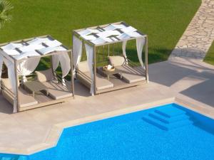 an overhead view of two gazebos and a pool at San Giovanni Beach Resort and Suites in Lefkada Town