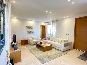 uma sala de estar com um sofá e uma televisão em Bright & Lovely 2 Beds Apartment in Scarab Club, El Gouna em Hurghada