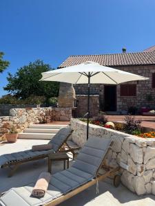 2 sedie a sdraio e un ombrellone su un patio di Villa Kate -with private pool and BBQ a Brusje