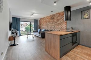 een keuken en een woonkamer met een bakstenen muur bij Rezydencja Wintera Apartments by Grand Apartments in Gdańsk