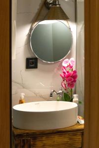 a bathroom sink with a mirror and pink flowers at Nice cabin in Cetinje