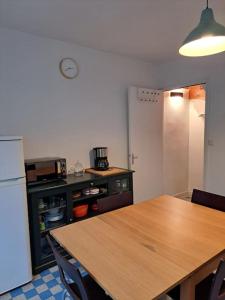 uma cozinha com uma mesa de madeira e um frigorífico em Logement atypique à Ornans em Ornans