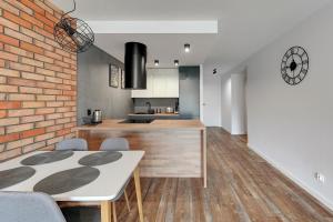 een keuken en eetkamer met een bakstenen muur bij Rezydencja Wintera Apartments by Grand Apartments in Gdańsk