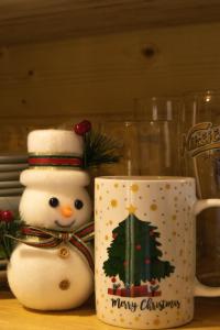 a christmas mug with a snowman and a christmas tree on it at Nice cabin in Cetinje