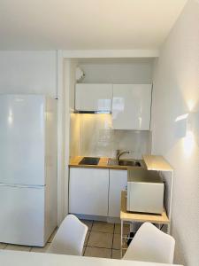 eine Küche mit weißen Schränken und einem weißen Kühlschrank in der Unterkunft Résidence Graziella Studio 301 in Juan-les-Pins