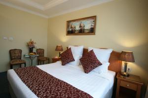 a hotel room with a bed and two chairs at فندق قصر الأزهر - Al-Azhar Palace Hotel in Mecca +25 photos