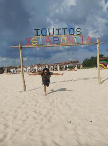 eine Person, die am Strand vor einem Schild läuft in der Unterkunft URREAHOUSE IQUITOS in Iquitos