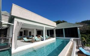 a villa with a swimming pool and a house at Lux Villa w/ Stunning Panoramic Ocean Views in Bequia