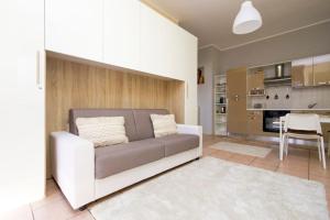 ein Wohnzimmer mit einem Sofa und einer Küche in der Unterkunft STAR Suite, Malpensa - Rho Fiera Milano 15 min in Legnano