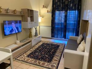 ein Wohnzimmer mit einem TV und einem Sofa in der Unterkunft STAR Suite, Malpensa - Rho Fiera Milano 15 min in Legnano