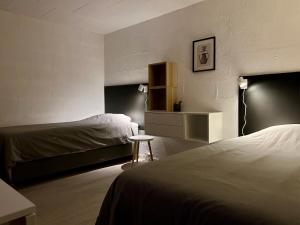 um quarto de hotel com duas camas e uma mesa em Simple room em Trondheim