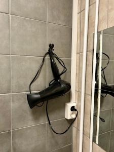 a blow dryer hanging on a wall in a bathroom at Simple room in Trondheim