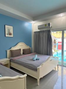 a bedroom with two beds and a blue wall at Unique Pool Villa Resort in Ban Map Fakthong +31 photos