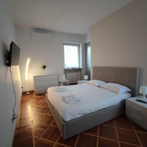 a bedroom with a large white bed and a window at B&B Casa Lilla in Verzuolo