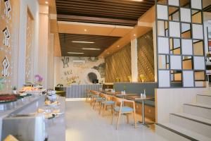 Sahid T-More Hotel في كوبانغ: مطعم فيه طاولات وكراسي في الغرفة