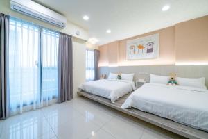 a bedroom with two beds and a large window at Little House Homestay in Wujie