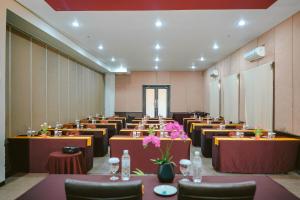a banquet hall with tables and chairs and flowers at Sahid T-More Hotel in Kupang