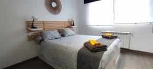 a bedroom with a bed with towels on it at Apartamento en Ultramar in Ferrol