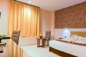 Un pat sau paturi într-o cameră la Sahid T-More Hotel