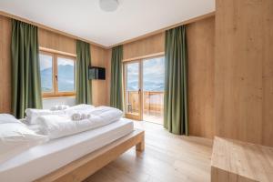 a bedroom with two beds and a large window at aMa Dolomiti Resort in Vigo di Cadore