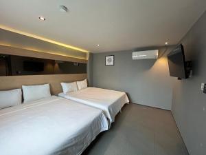 a hotel room with two beds and a flat screen tv at Deluxe motel in Geoje 