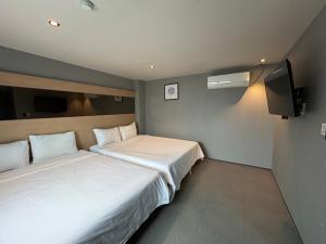 a hotel room with two beds and a tv at Deluxe motel in Geoje 