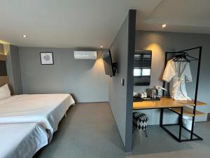a bedroom with a bed and a desk with a television at Deluxe motel in Geoje 