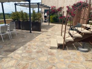 een patio met een tafel en stoelen en een parasol bij Alojamientos El Horno in Montejo de la Sierra