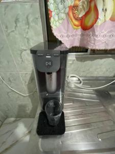 a black coffee maker sitting in a shelf at Quitinet Simples e aconchegante. in Bertioga