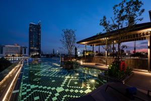 una piscina en la azotea de un edificio por la noche en Ten Six Hundred, Chao Phraya, Bangkok by Preference, managed by The Ascott Limited en Bangkok