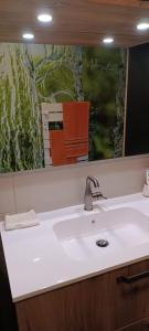 baño con lavabo y espejo grande en chambre moderne en campagne en Le Calvaire