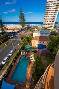 Una vista aérea de una piscina junto a una playa. en Warringa Surf Holiday Apartments, en Gold Coast