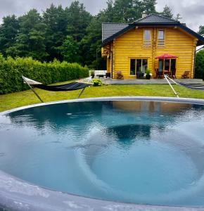 una gran piscina frente a una casa en Eco-House Ainaži, en Ainaži