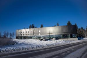 um edifício ao lado de uma estrada coberta de neve em Playhotel em Mjölby