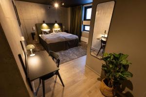 Cette chambre comprend un lit, une table et un miroir. dans l'établissement Playhotel, à Mjölby