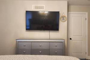 een dressoir met een flatscreen-tv aan de muur bij Perfect Family Home in Collins Bay