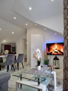 a living room with a table and a fireplace at Luxury Apartment Megy in Otočac