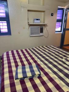 a bed in a room with a checkered blanket at Navata Lodge in Pulivendla