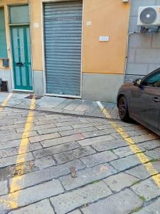 un coche aparcado en un aparcamiento al lado de un edificio en rolando 20B en Génova
