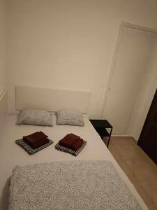 Una cama blanca con dos almohadas encima. en Paloma-habitacion del piso, en Alicante