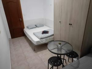 um pequeno quarto com uma pequena mesa e uma cama em Paloma-habitacion del piso em Alicante