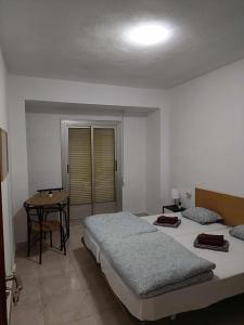 um quarto com duas camas e uma mesa em Paloma-habitacion del piso em Alicante